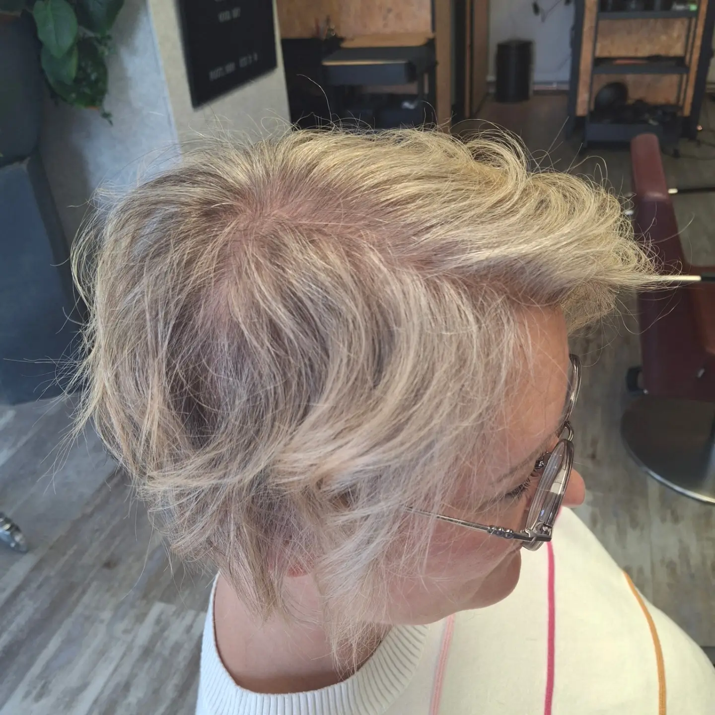 Kurzer, welliger Blondlook mit weiß-grauem Naturansatz und weichen Farbübergängen – Arbeit von Nathalie bei roots hair.