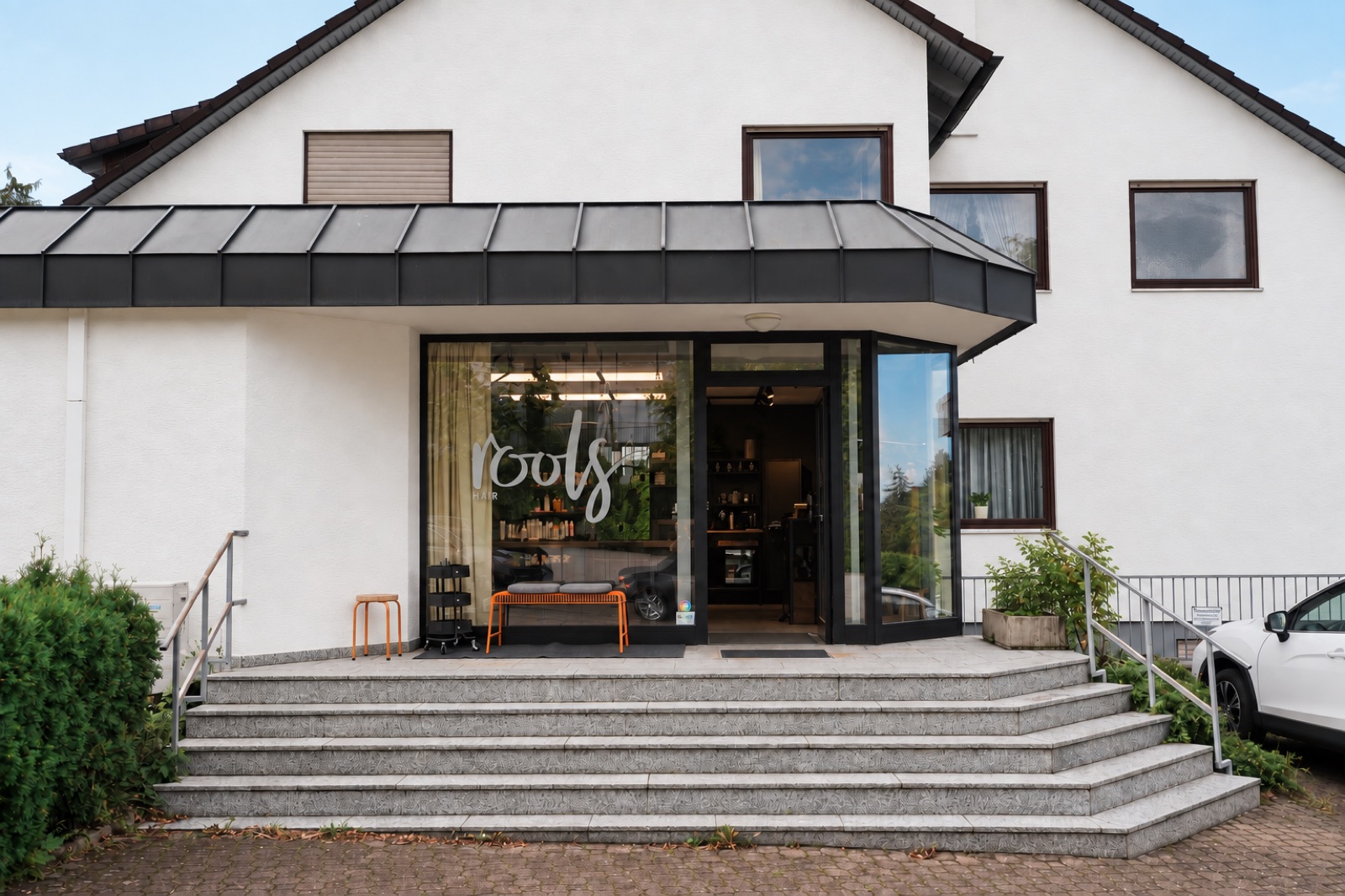 Außenansicht des roots hair Salons mit Treppe zum Eingang