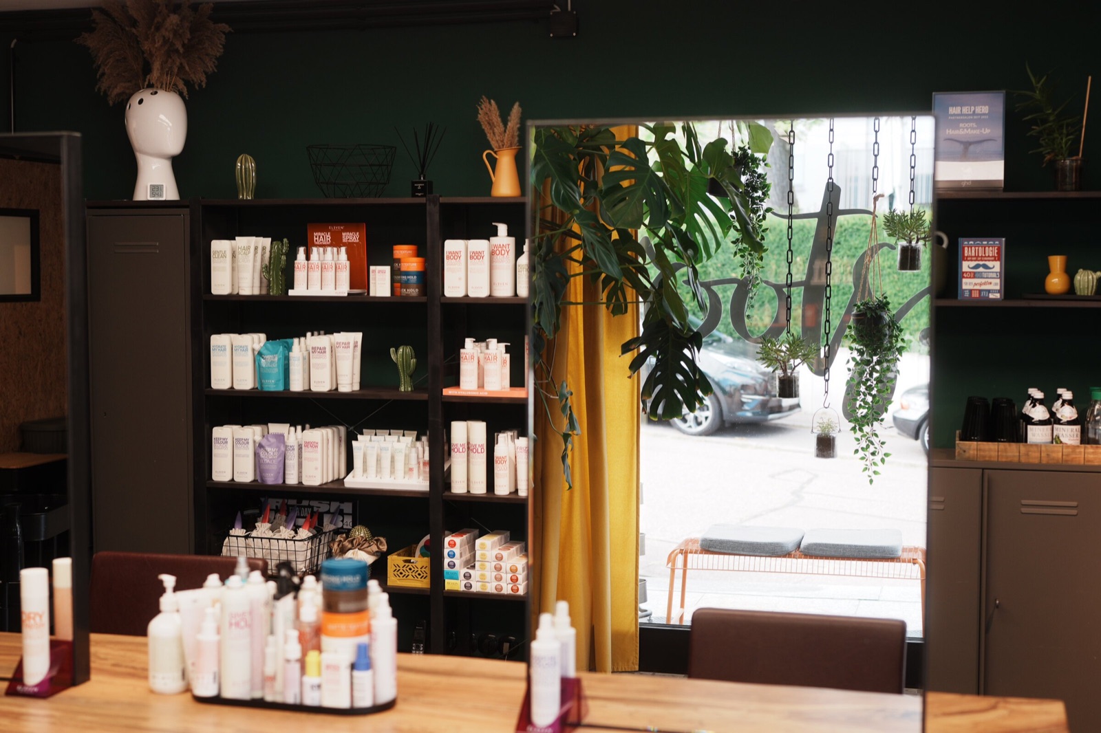 ELEVEN-Pflegeregal und bepflanztes Schaufenster bei roots hair